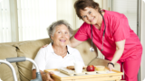 caregiver assisting her patient in her meal